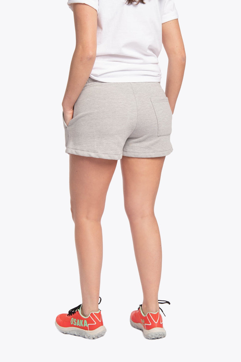 Woman wearing the Osaka women shorts in grey with neon green logo. Back view