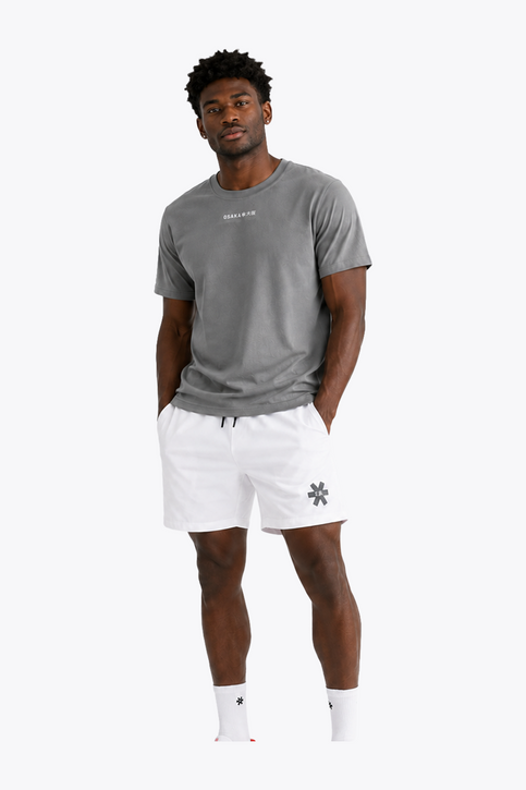Osaka Men Apex Training Tee | Quiet Gray Black male model wearing Osaka Men’s Apex Training Tee in Quiet Gray and white training shorts, showcasing reflective chest branding, athletic fit, and breathable training fabric.