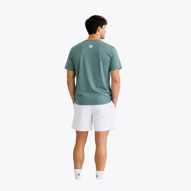 Male model wearing the Osaka Men’s Apex Training Tee in Pineneedle green and white training shorts, showcasing the back fit, reflective Osaka logo, and shoulder panel construction.