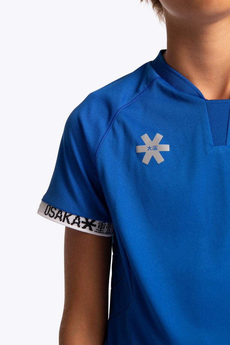 Boy wearing the Osaka Kids Jersey in Royal blue. Front detail logo view
