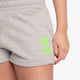 Woman wearing the Osaka women shorts in grey with neon green logo. Front detail logo view