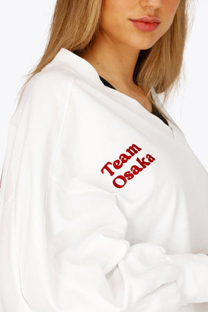 Osaka women v-neck cropped sweater white with logo in red. Front detail logo view