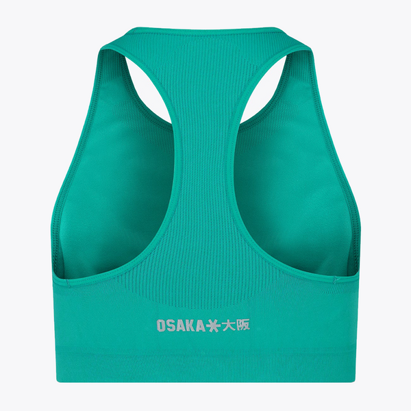 A teal green sports bra shown from the back, featuring a ribbed texture, wide shoulder straps, and a white printed logo that reads 'OSAKA小愛' on the lower backband, set against a plain white background. #BayouGreen