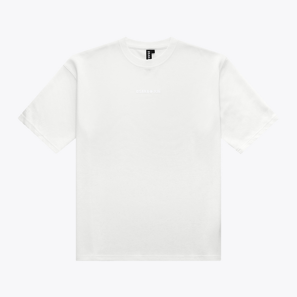 A white boxy crewneck t-shirt with a small, tonal embroidered logo on the center chest, displayed flat against a light gray background. | Osaka World USA #White