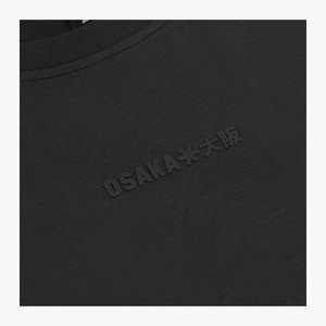 Close-up of a black crewneck sweatshirt with embossed 'OSAKA**大阪' text on the chest and a black neck label reading 'OSAKA'. | Osaka World USA #Black