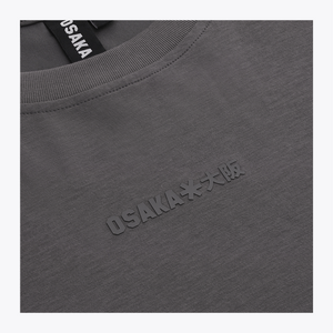 Close-up of a dark gray crewneck sweatshirt with embossed 'OSAKA**大阪' text on the chest and a black neck label reading 'OSAKA'. | Osaka World USA #DarkGrey
