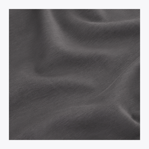 A close-up of dark gray fabric with soft folds and a smooth texture, presented as a material or color sample. | Osaka World USA #DarkGrey