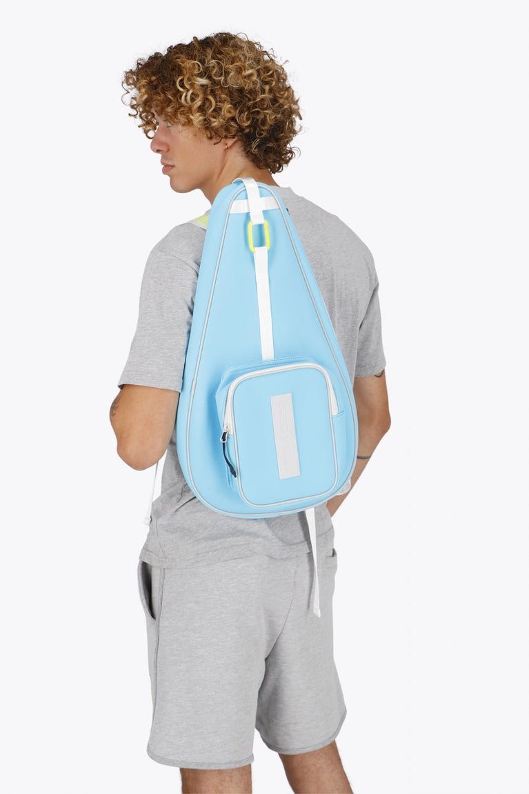 Osaka neoprene padel bag in light blue with logo in white. Man wearing the bag