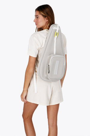 Osaka neoprene padel bag in light grey with logo in white. Woman wearing the bag