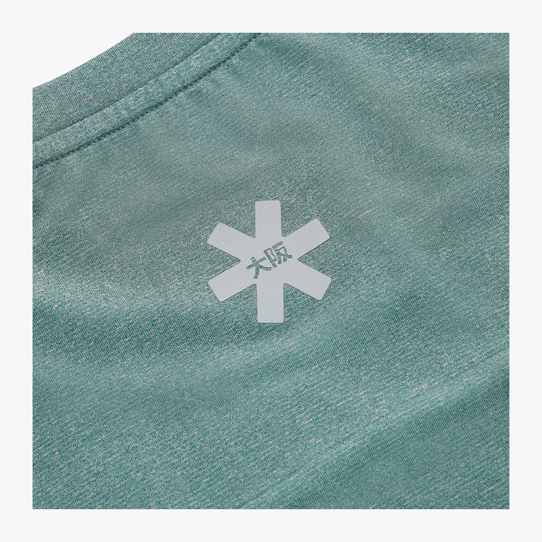 Close-up of the reflective Osaka star logo positioned on the upper back of the Pineneedle green Apex Training Tee.