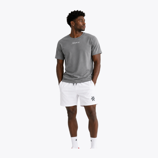 Black male model wearing Osaka Men’s Apex Training Tee in Quiet Gray and white training shorts, showcasing reflective chest branding, athletic fit, and breathable training fabric. #QuiteGray