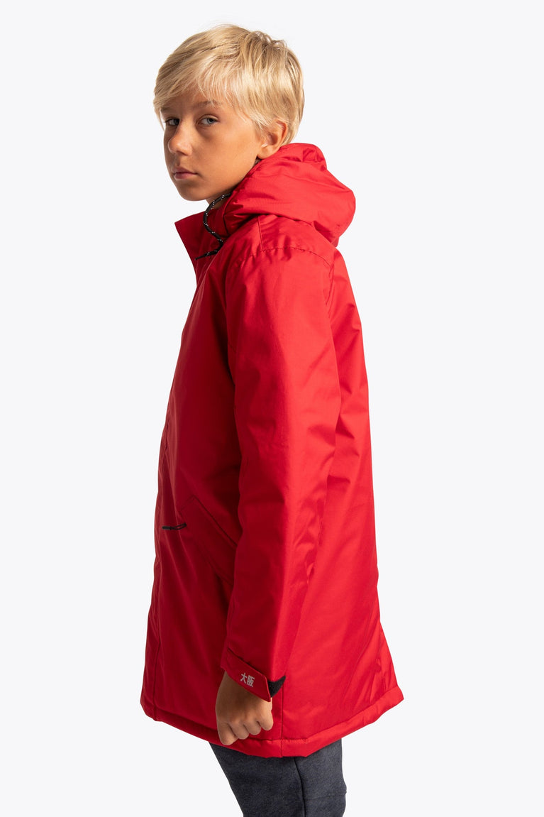 Boy wearing the Osaka Kids Stadium Jacket in Red. Side view