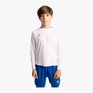 A young boy wearing a white long-sleeve athletic shirt with a small gray snowflake logo on the left chest, paired with royal blue shorts, against a plain white background. #White