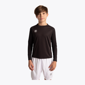 A boy modeling a dark brown long-sleeve athletic shirt with a small white flower logo on the left chest, paired with white shorts, against a plain white background. #Black