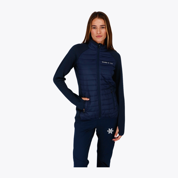 A woman modeling a dark navy blue puffer jacket with long sleeves and matching navy pants against a light gray background. #Navy