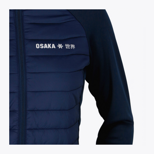 Close-up of a dark navy quilted puffer jacket with white 'OSAKA' text and Japanese characters on the chest, set against a plain light gray background. #Navy