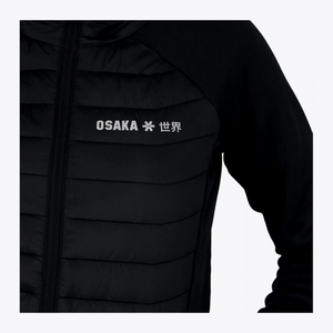 Close-up of a black puffer jacket with horizontal quilting, a front zipper, and white 'OSAKA' text with a star and Japanese character on the chest, shown against a light gray background. #Black