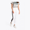 A model wearing white jogger-style pants with a black side stripe featuring white lettering, paired with a gray graphic t-shirt and white sneakers, against a plain white background. #White