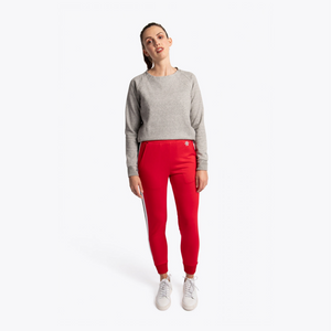 A woman modeling a light gray crewneck sweatshirt and bright red jogger-style pants with white side stripes, paired with white sneakers, against a plain white studio background. #Red